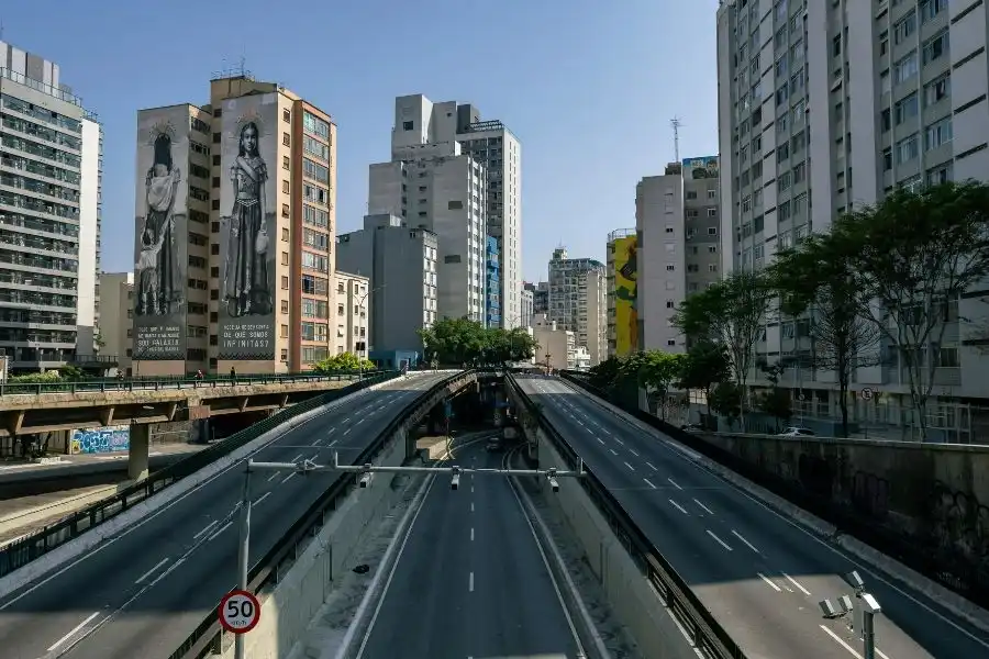 Vista urbana com prédios modernos e elevado, exemplo de planejamento de um arquiteto urbanista.